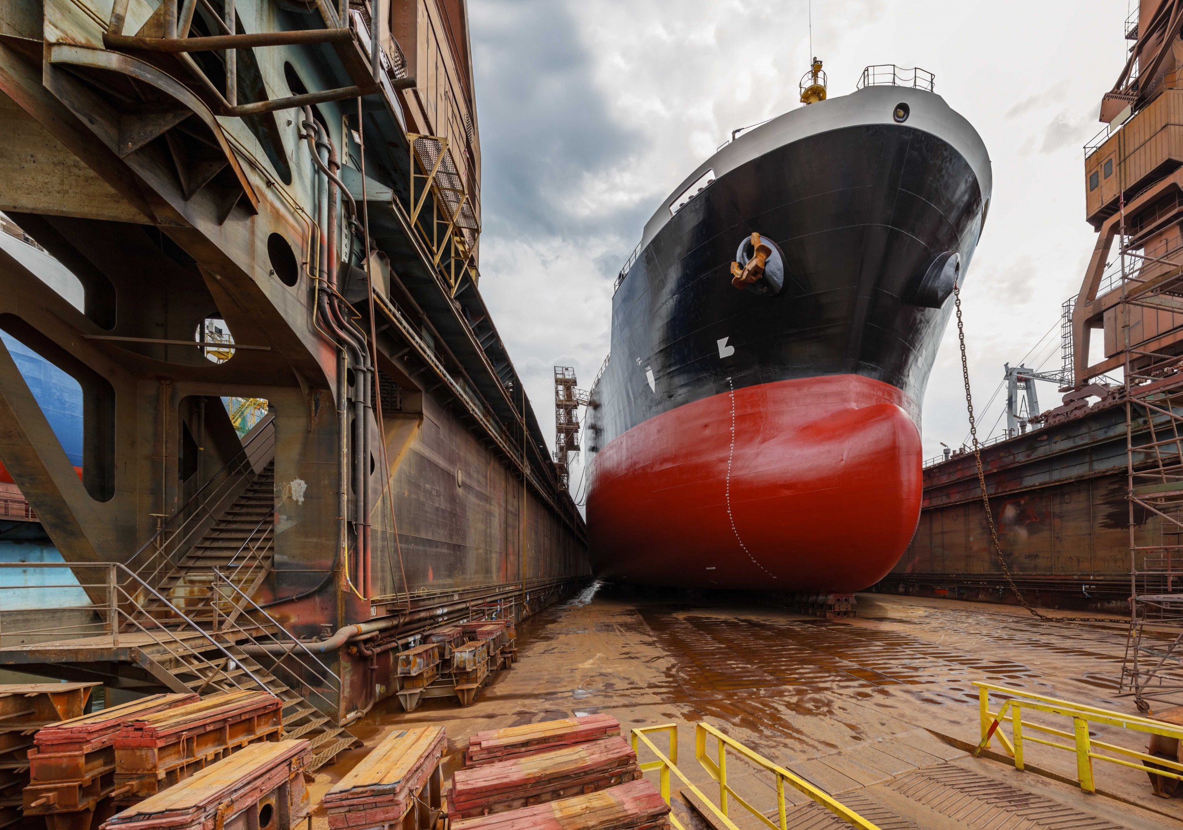 A large tanker ship is being renovated in shipyard
