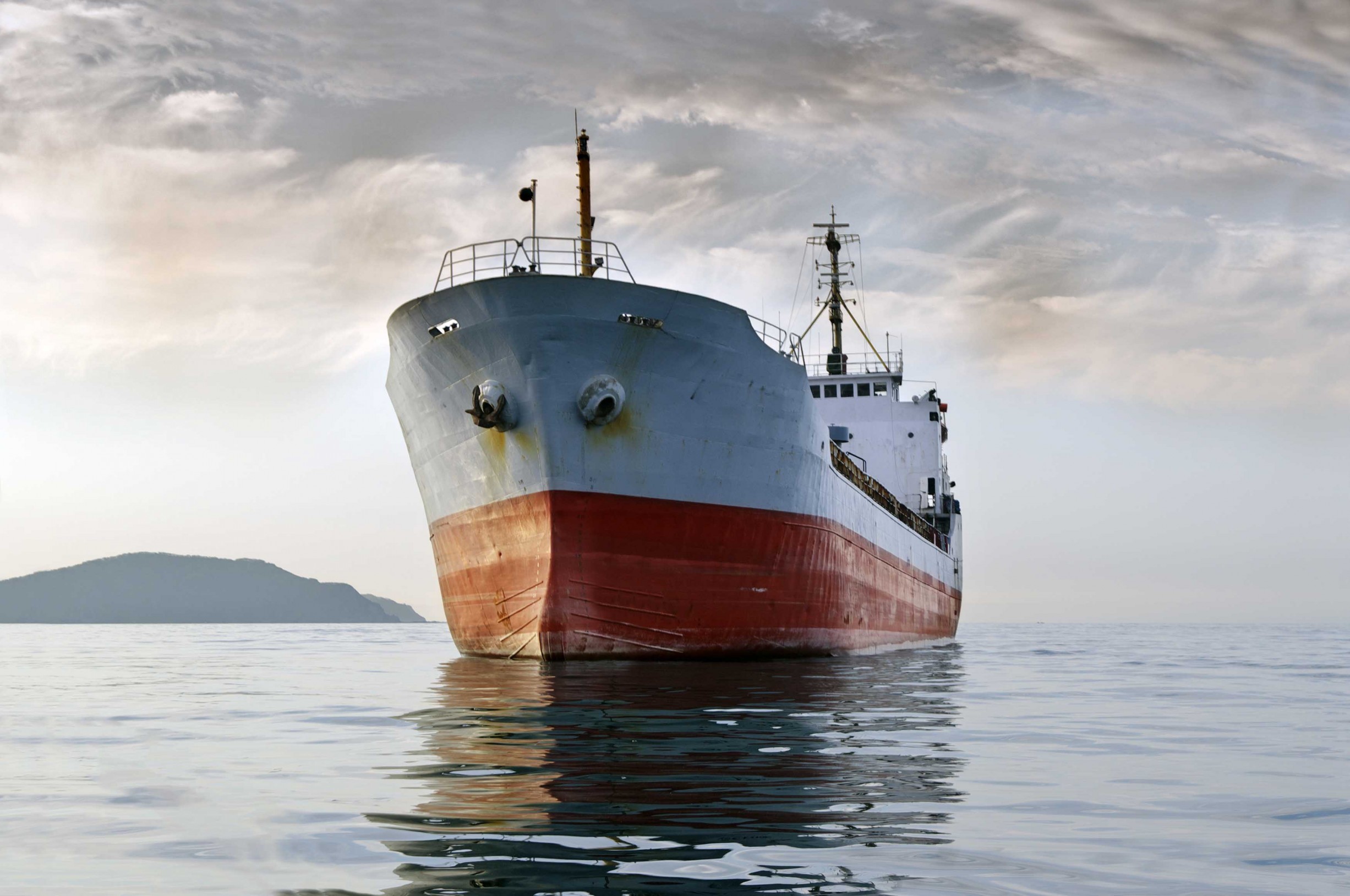 Large cargo ship at sea with calm, grey sky